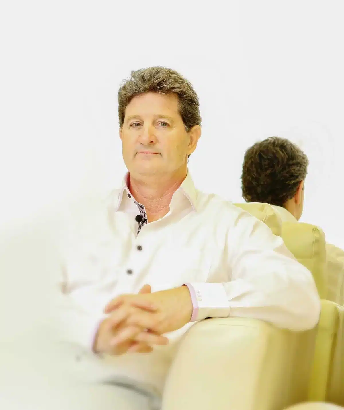 Dr. Robert J. Troell, MD, FACS, board-certified facial plastic surgeon in Las Vegas, seated portrait in a white shirt
